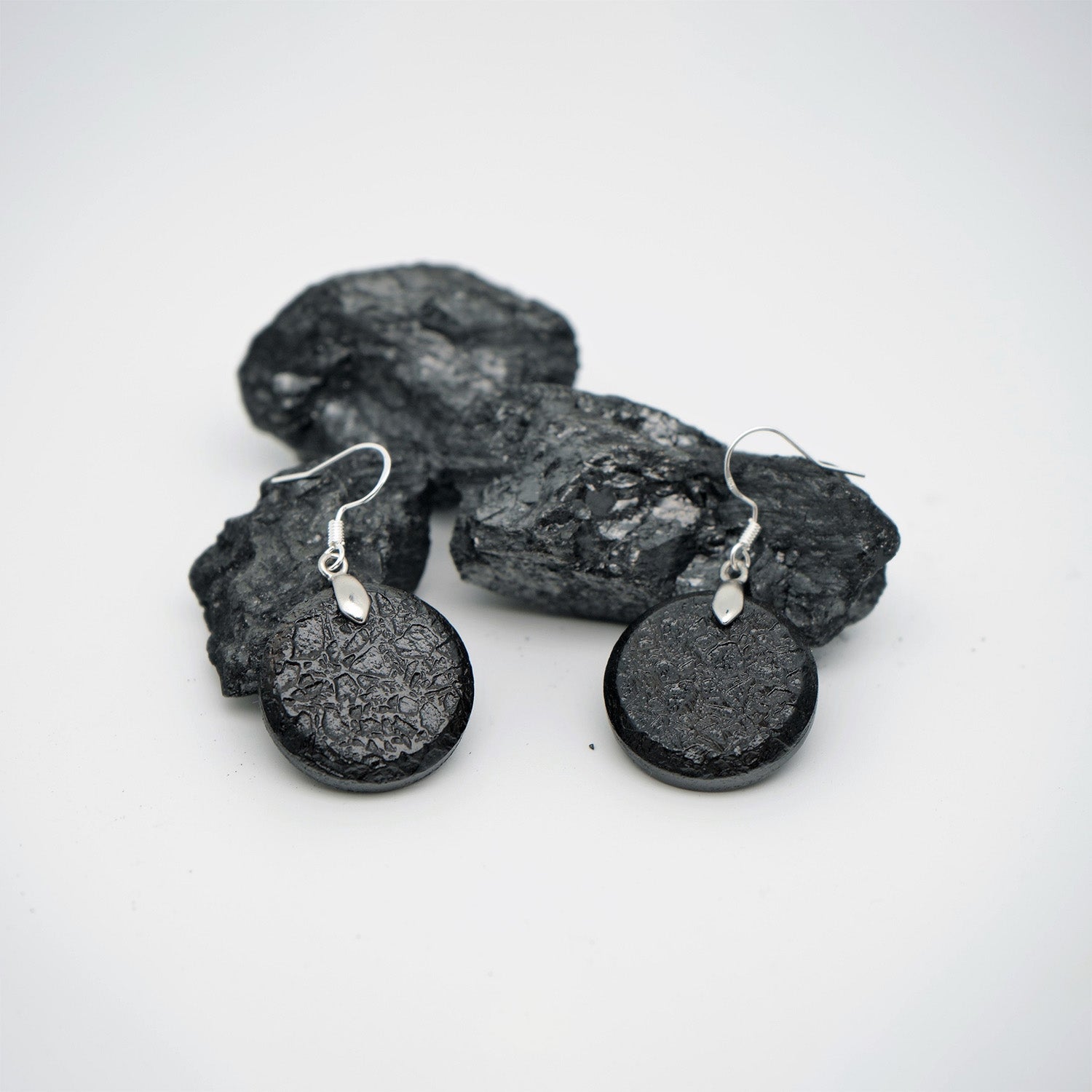 Round earrings in raw charcoal, silver metal