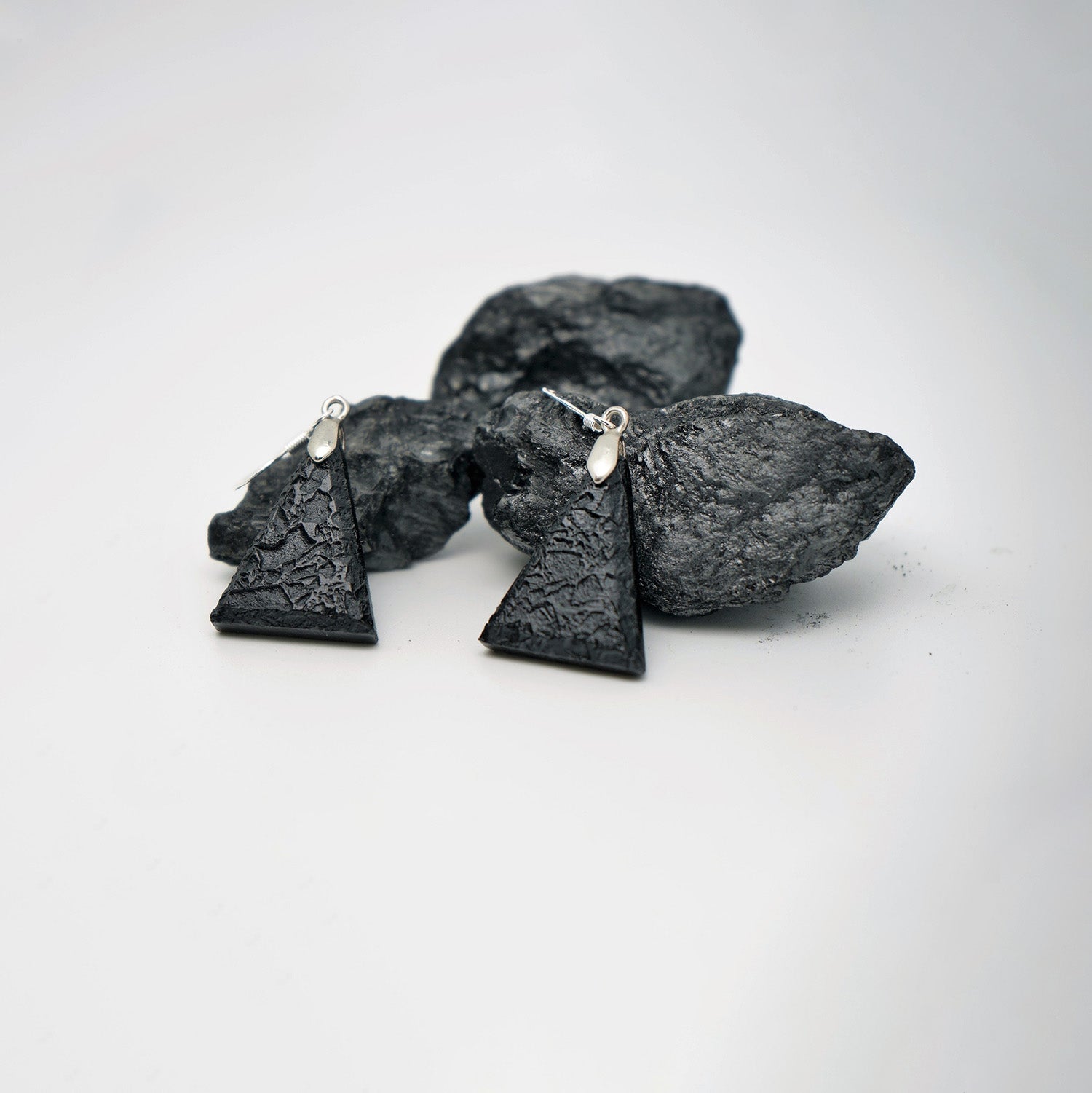 Triangle earrings in raw charcoal (silver metal)