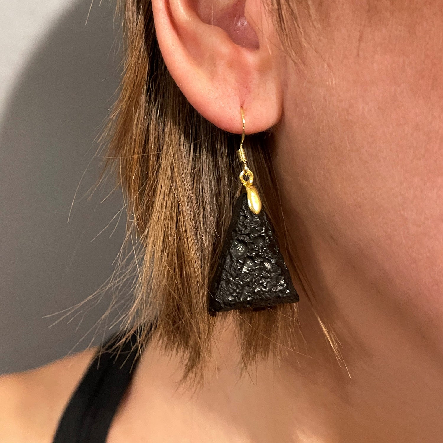 Triangle earrings in raw charcoal, gold metal